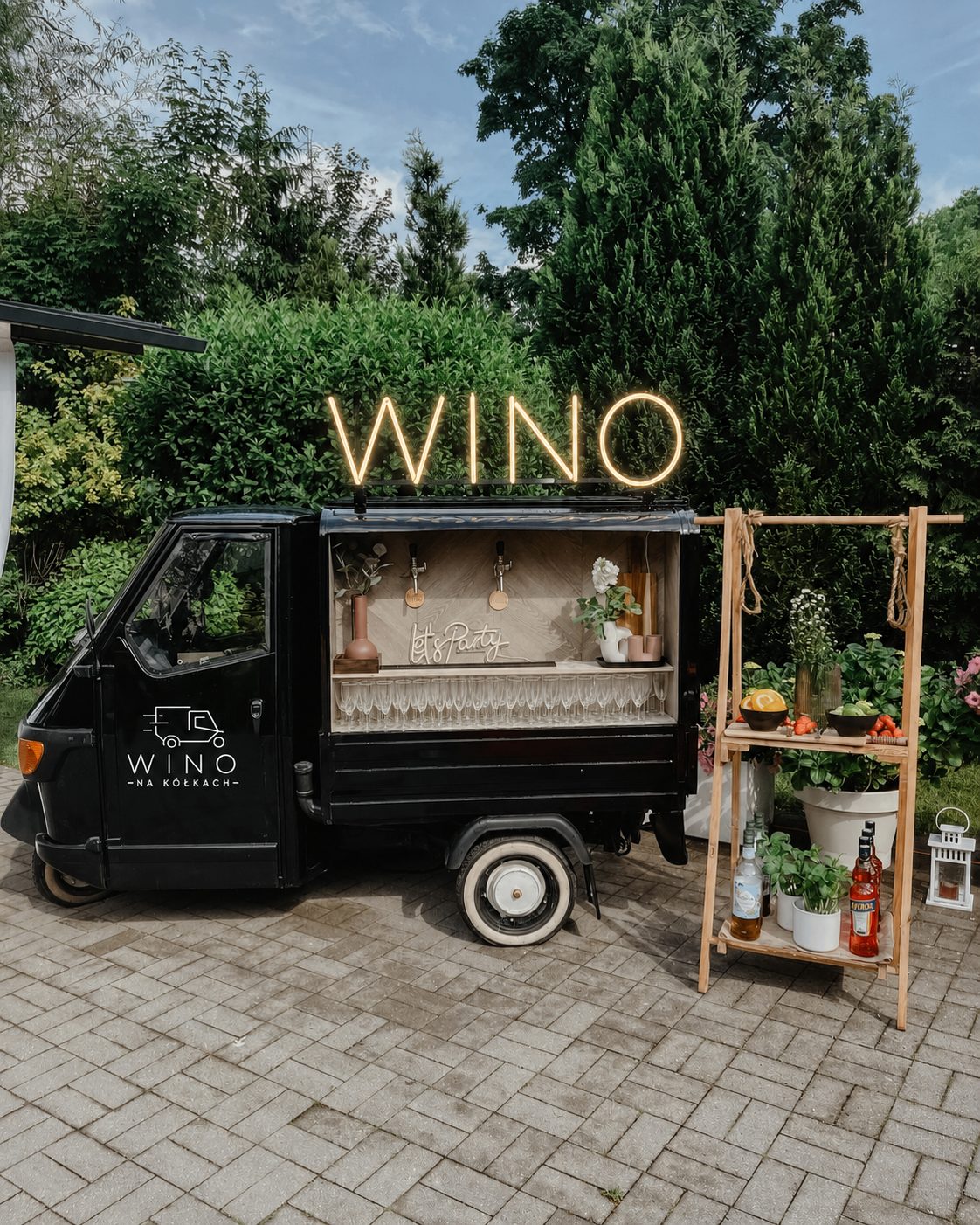 Wino na kółkach w ogrodowej aranżacji z neonem i strefą dodatków
